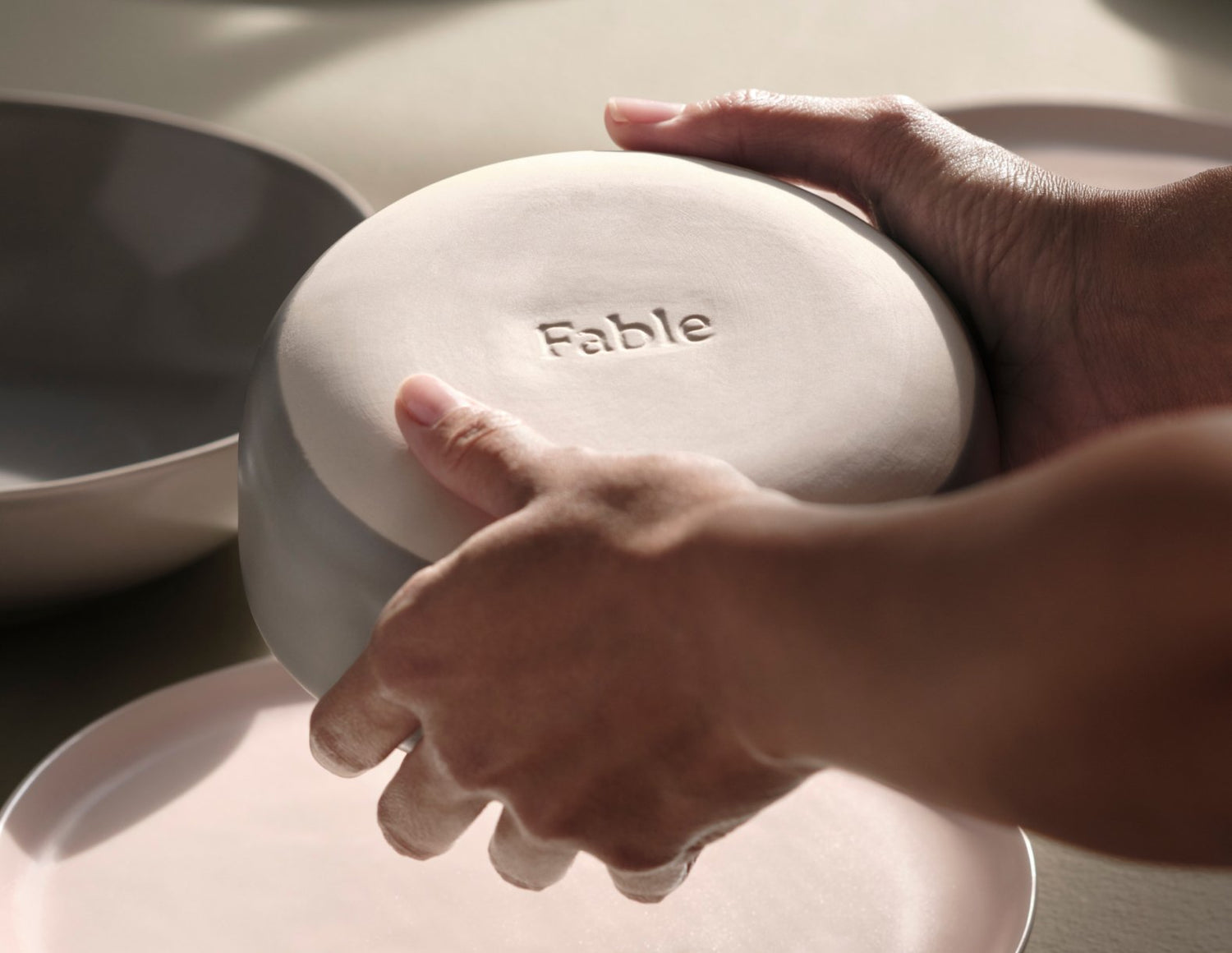 Someone holds a bowl upside down, showing a stamp that says "Fable" on the bottom.