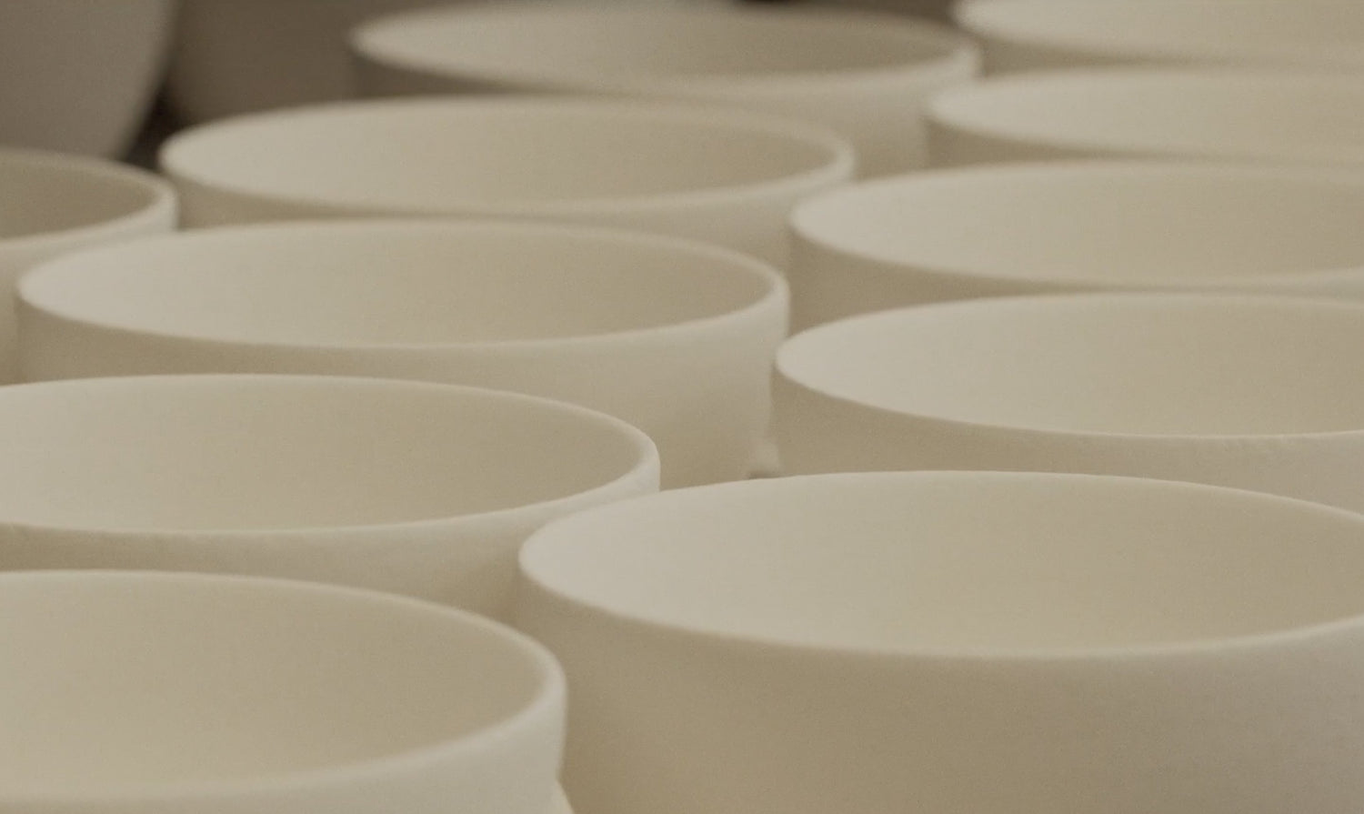 Many white bowls lined up side by side