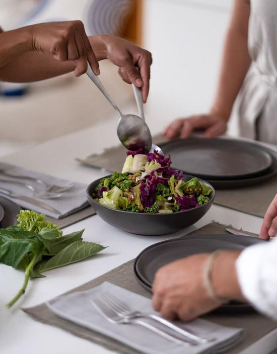 Salad being served from a communal bowl 